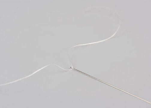 Needle threaded with white thread